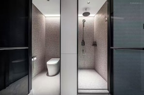 A modern bathroom with a toilet, shower, and glass enclosure.