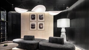 A modern lounge area with a sofa set, a table, and a lamp. - Intercity Shanghai South Xizang Road (Shanghai)