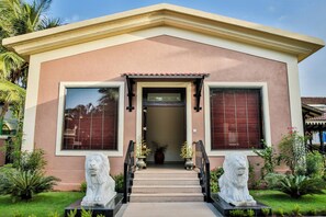 A two-story house with a central entrance, a small porch, and two stone lion statues. - De Mandarin Beach Resort Suites & Villas Goa (Candolim)