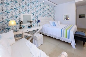 Ein Schlafzimmer mit einem Bett, einem Schreibtisch, einem Stuhl, einem kleinen Tisch, einer Lampe, einem Spiegel und einer Bank.