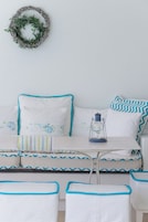 A room with a bed, pillows, a lantern, and a wall-mounted wreath.