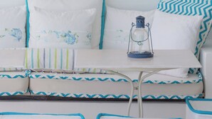 Una habitación con cama, almohadas, un farol y una guirnalda en la pared.