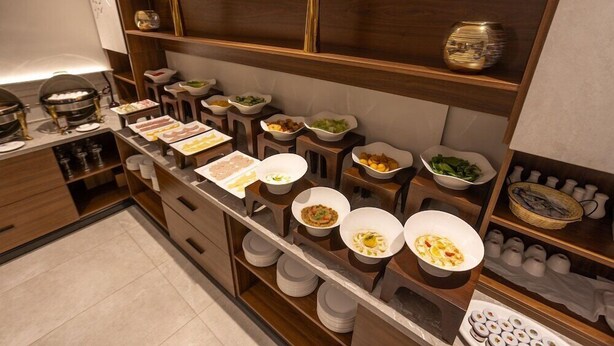 A buffet setup with various food items and serving dishes. - Skyline Hotel & Suite (Tabuk)