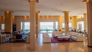 A spacious lobby with high ceilings, large windows, and a view of the outdoors. - Sun Africa Beach Resort (Mombasa)