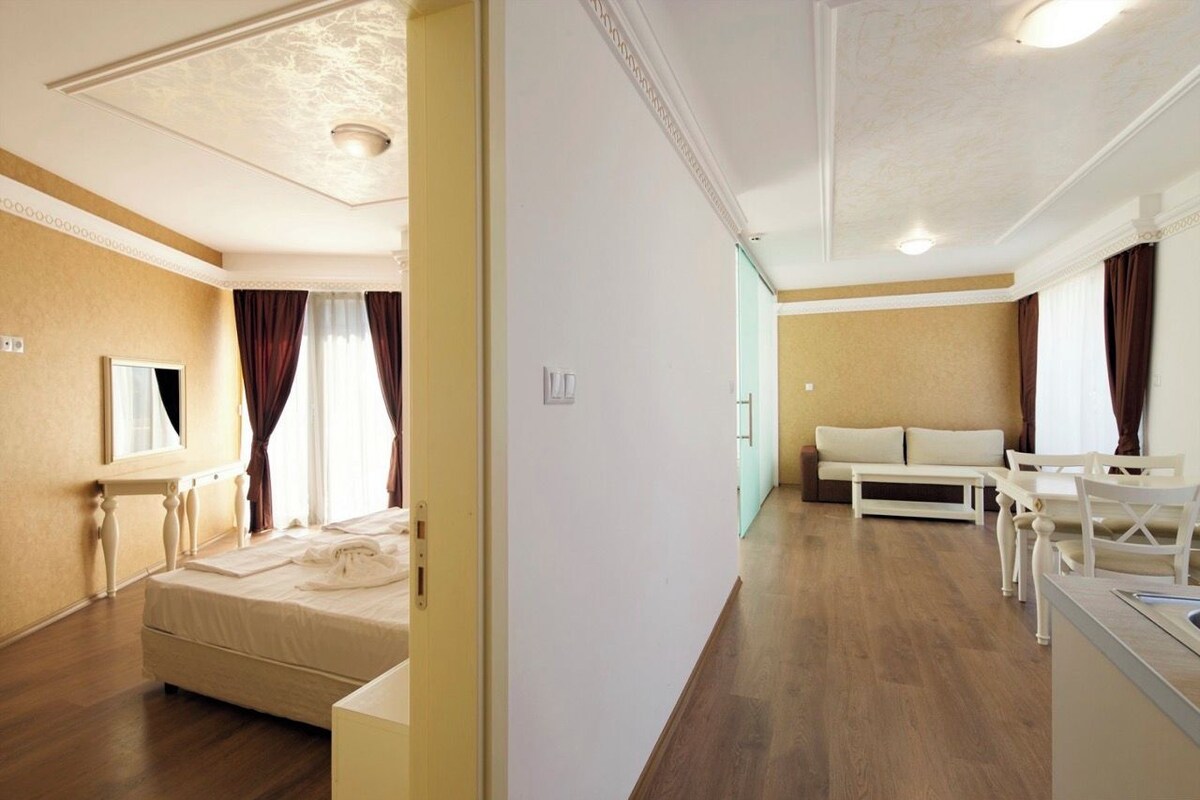 A hotel room with a bed, a desk, and a sofa.
