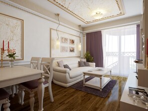 A living room with a white sofa, a coffee table, a dining table with chairs, and a chandelier. - Golden Rainbow (Nessebar)