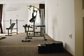 A gym with exercise equipment, a bench, and weight stacks. - Golden Rainbow (Nessebar)