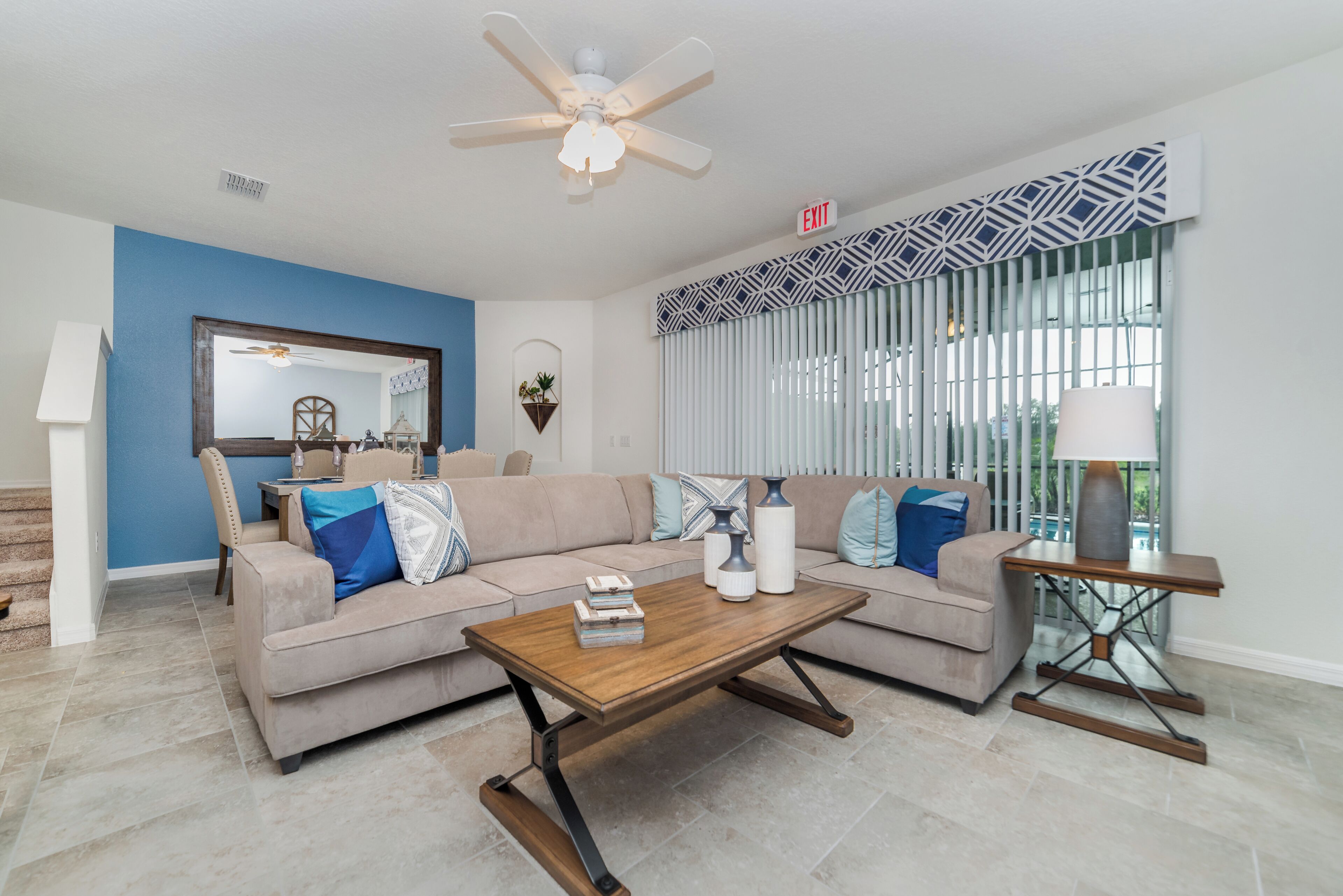 A living room with a sofa, coffee table, and a ceiling fan.