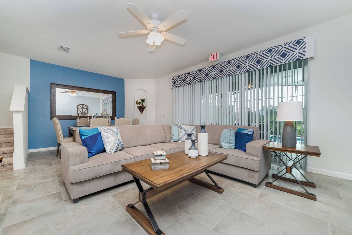 A living room with a sofa, coffee table, and a ceiling fan.