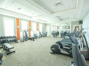Un gimnasio con cintas de correr, máquinas de pesas y mancuernas.