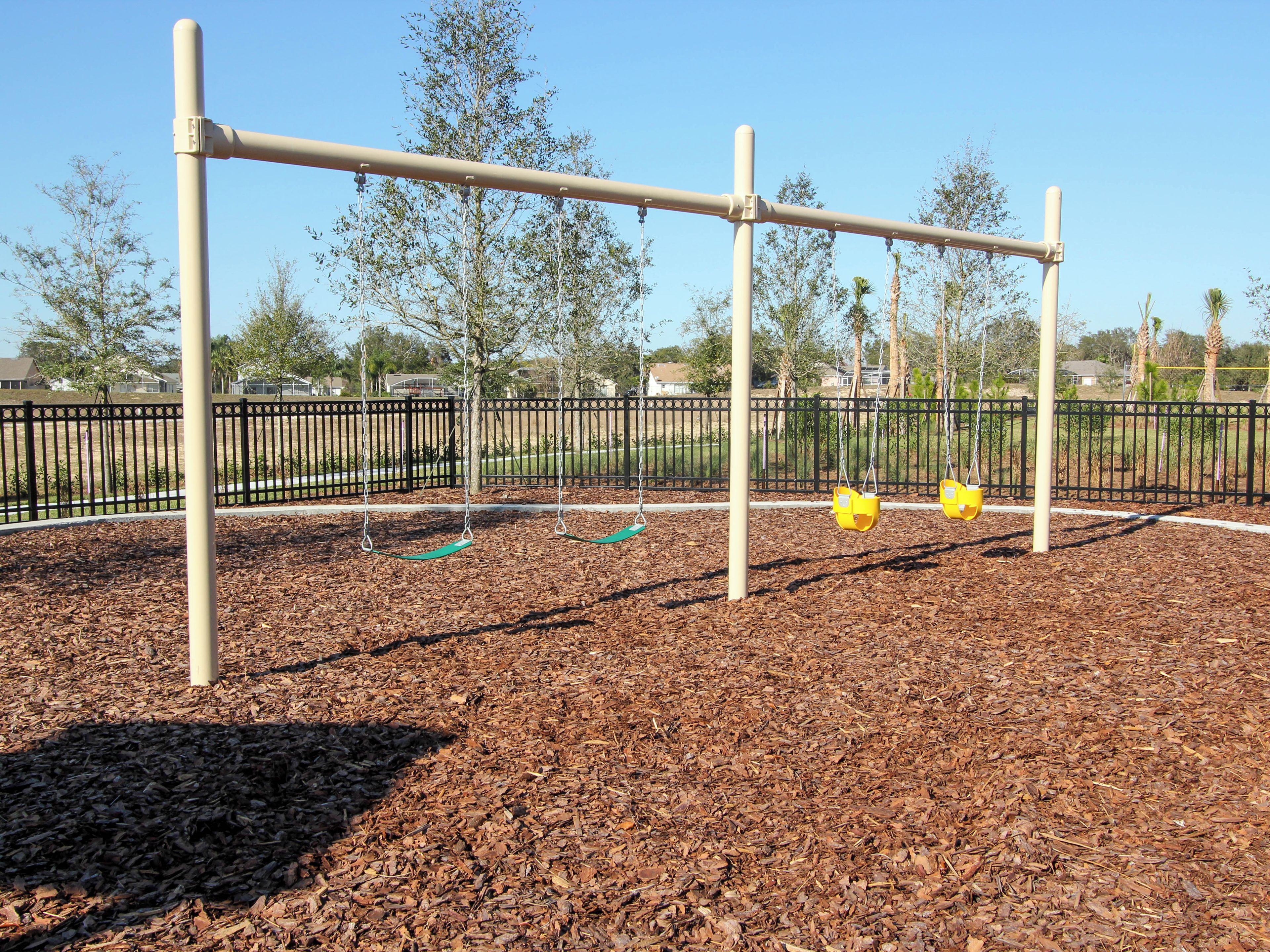 A playground with swings and a fence.
