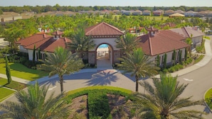 A residential area with houses, a central archway, and palm trees. - Solterra Resort Homes (Davenport)
