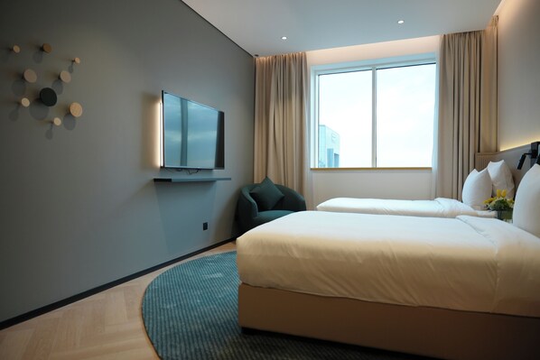 A hotel room with a bed, a TV, a window with curtains, and a wall-mounted light fixture. - Novotel Riyadh Al Anoud (Al Muzahimiyah)