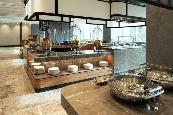 A modern kitchen with a marble countertop, stainless steel appliances, and a view of the city.