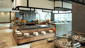 A modern kitchen with a marble countertop, stainless steel appliances, and a view of the city.