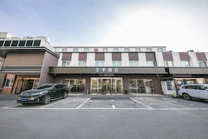 A hotel with a modern facade, a parking lot, and a clear entrance. - Ji Hotel Beijing Guomao (Beijing)