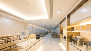 A modern hotel lobby with a long reception desk, seating area, and a kitchen visible on the right. - Ji Hotel Beijing Guomao (Beijing)