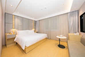 A modern hotel room with a large bed, bedside tables, a small round table, and a TV. - Ji Hotel Beijing Guomao (Beijing)