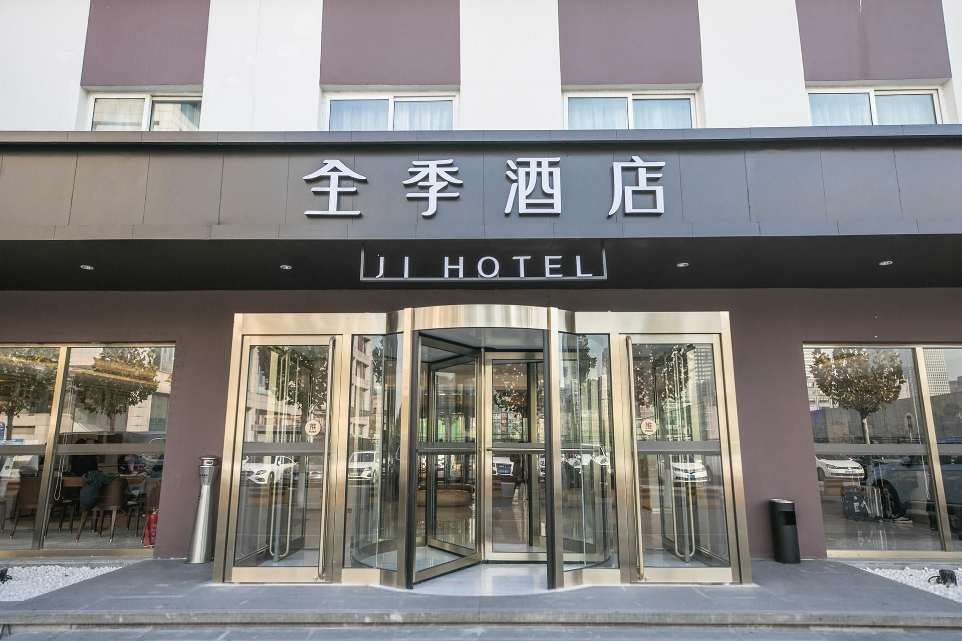 A hotel entrance with a revolving door and glass doors.