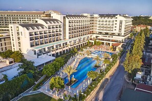 Un hotel con varias plantas, piscina y aparcamiento.