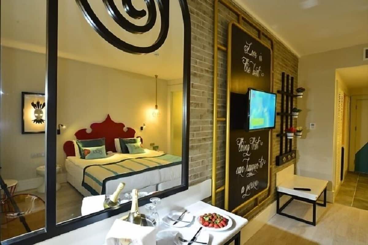 Ein Hotelzimmer mit einem Bett, einem Fernseher, einem Spiegel und einer Wand mit motivierenden Zitaten.