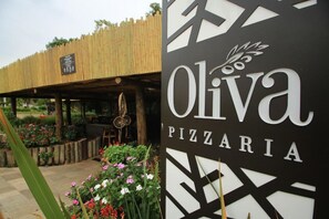 A sign for 'Oliva Pizzeria' with a geometric design and a logo. - Rio Quente Resorts Refugio Grand Premium (Rio Quente)