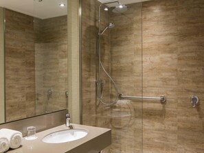 A modern bathroom with a glass-enclosed shower, a vanity with a sink, and a mirror. - Mercure Concepcion (Concepción)