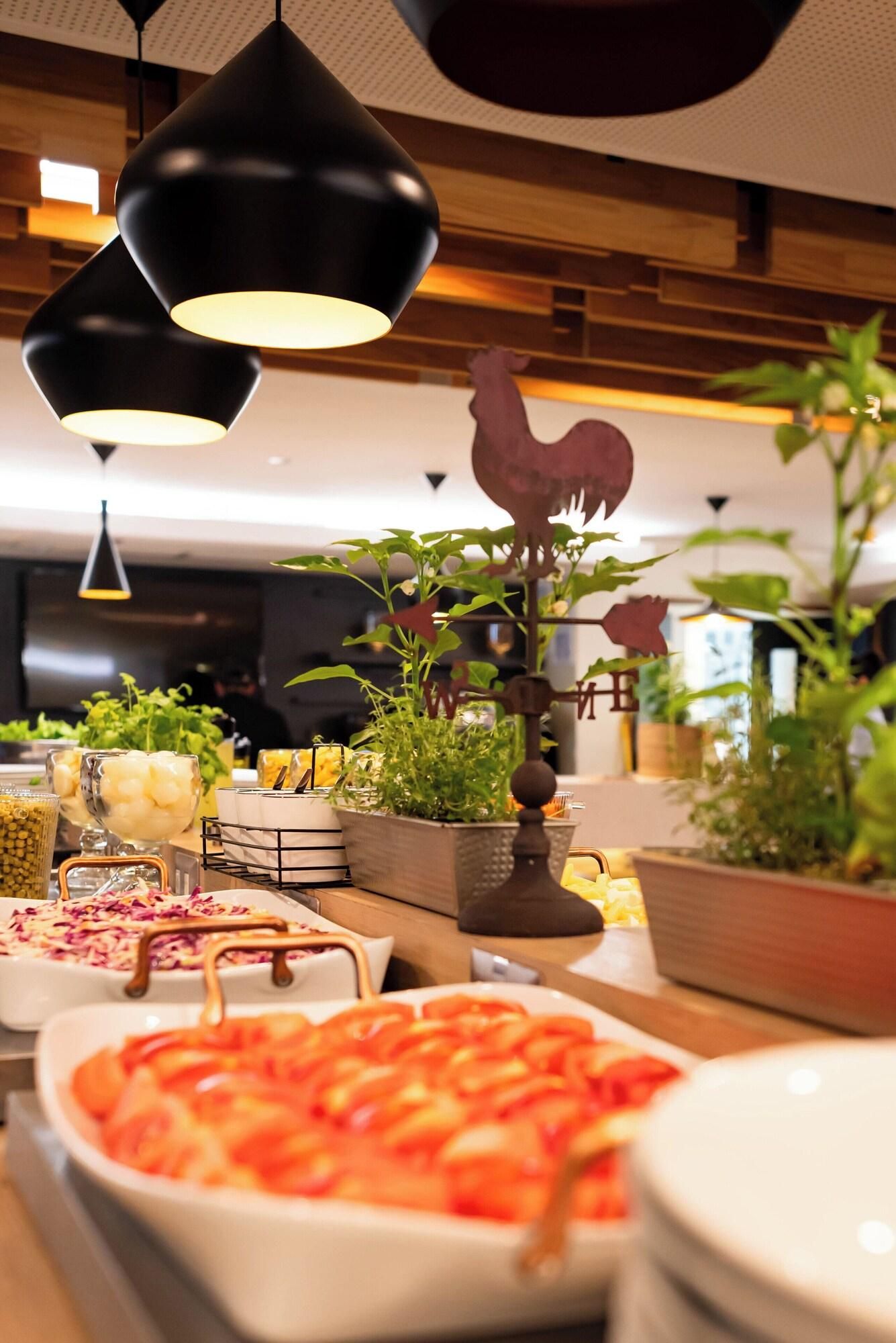 A buffet setup with various food items and a decorative rooster.