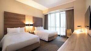 A hotel room with two beds, a desk, a TV, and a window with curtains. - Mercure Concepcion (Concepción)