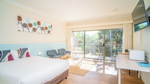 A hotel room with a bed, a desk, a TV, and a balcony with chairs. - Quality Hotel Ballina (Ballina)