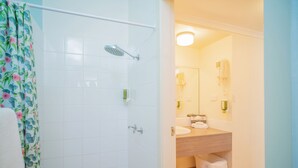 A bathroom with a shower, toilet, sink, and mirror. - Quality Hotel Ballina (Ballina)
