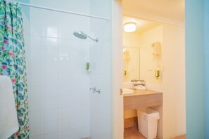 A bathroom with a shower, toilet, sink, and mirror. - Quality Hotel Ballina (Ballina)