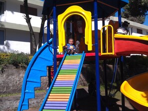 Ein Spielplatz mit Rutsche und Klettergerüsten.