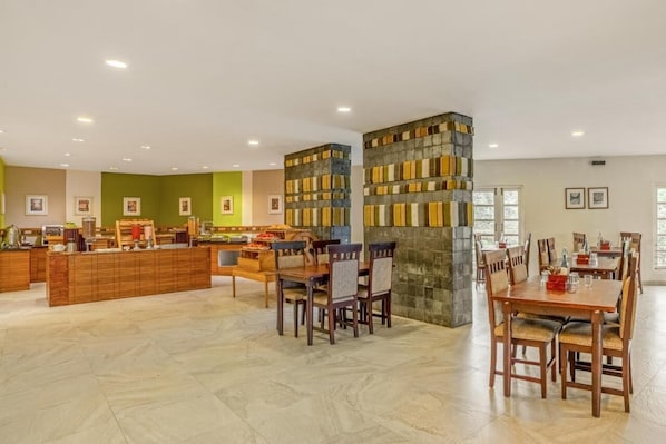 A hotel lobby with a reception desk, seating area, and a stone pillar.