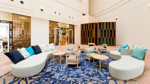 A modern lobby with a sofa, chairs, and a patterned carpet. - ANA Holiday Inn Resort Miyazaki (Miyazaki)