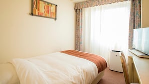 A hotel room with a bed, a television, and a window with curtains. - ANA Holiday Inn Resort Miyazaki (Miyazaki)