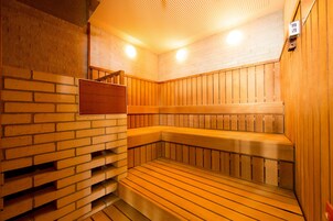 Una sauna con bancos de madera y pared de ladrillo.