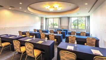 A conference room with tables, chairs, and a ceiling light fixture.