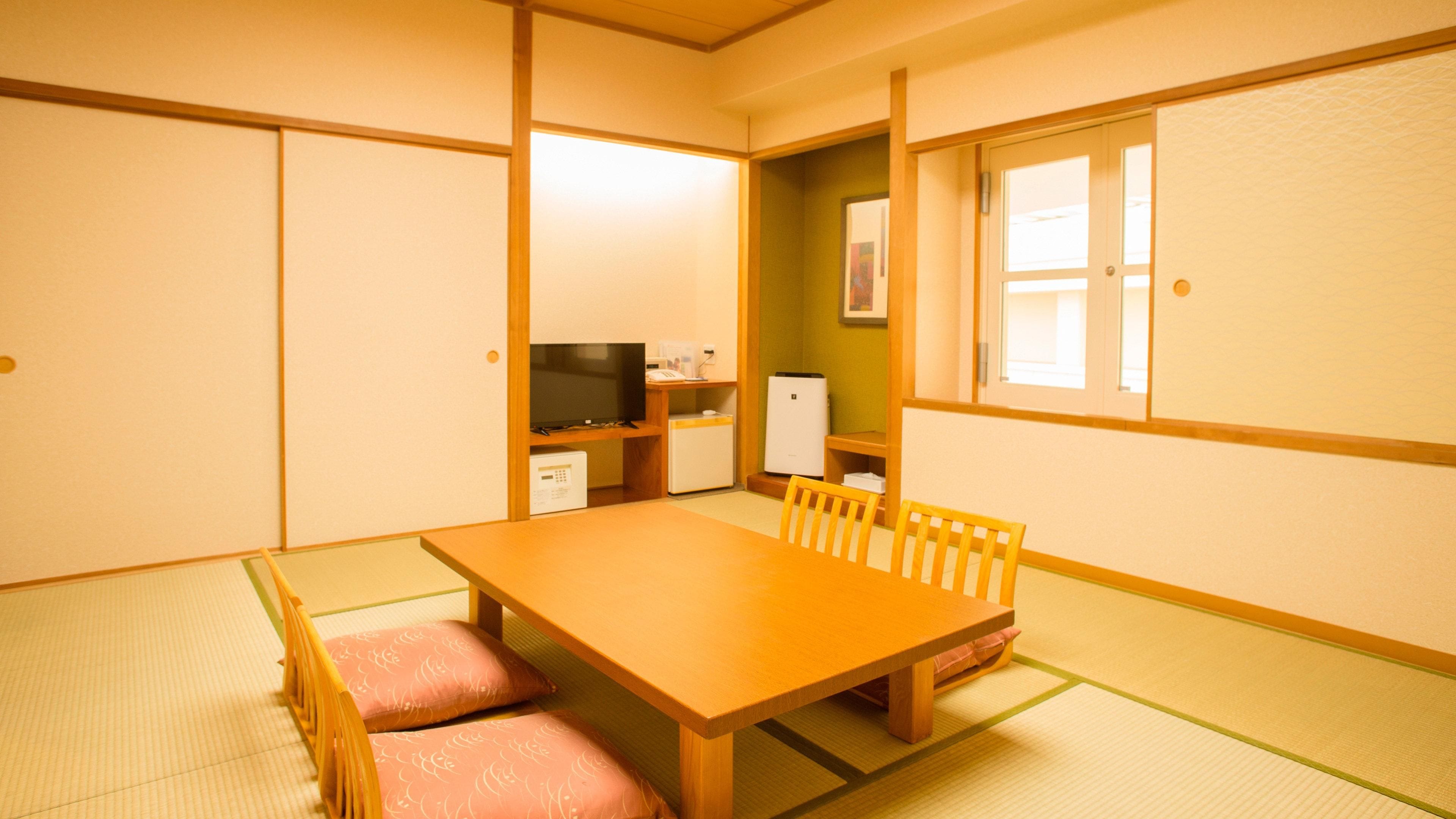 A traditional Japanese room with tatami flooring, a wooden table, and a television.