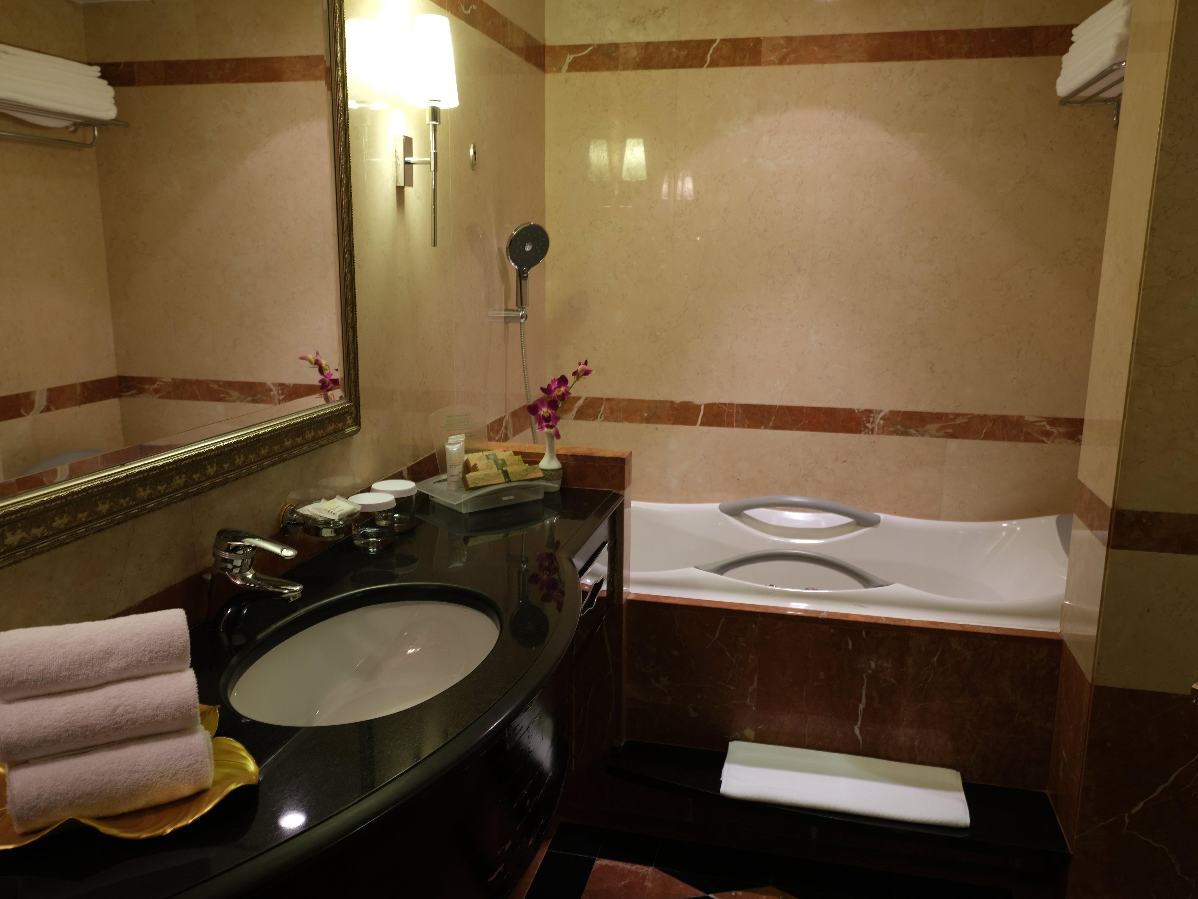 A bathroom with a black sink, a mirror, a toilet, and a towel rack.