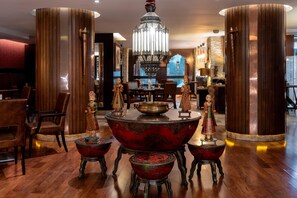 A dining area with a central round table, ornate chairs, and a chandelier. - Holiday Inn Kuwait Al Thuraya City (Farwaniya)