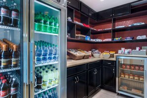 A kitchen with a refrigerator stocked with beverages, a microwave, and a sink. - Dulles Suites (Sterling)