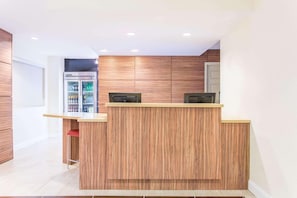 A modern kitchen with wooden cabinets, a built-in refrigerator, and a bar counter.