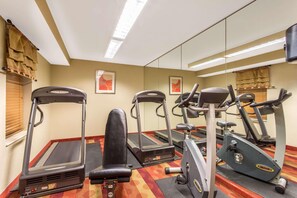 A gym with treadmills, a stationary bike, and a rowing machine. - Dulles Suites (Sterling)