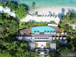 An aerial view of a resort with a swimming pool, beach, and palm trees. - Conrad Koh Samui Resid (Koh Samui)