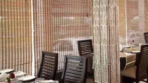 Un restaurante de diseño moderno, con una mezcla de mobiliario de madera y metal, una pared con motivos y una vista despejada del comedor.