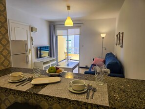A kitchen with a dining area, a TV, and a balcony with a view. - One bedroom, balcony, Wi-Fi, El Médano centre (El Médano)