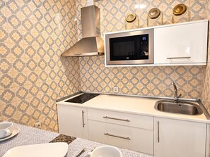 A modern kitchen with a microwave, stove, and sink. - One bedroom, balcony, Wi-Fi, El Médano centre (El Médano)