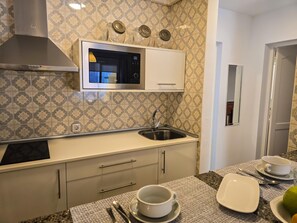 A kitchen with a microwave, stainless steel sink, and patterned backsplash. - One bedroom, balcony, Wi-Fi, El Médano centre (El Médano)