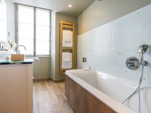 A modern bathroom with a bathtub, a shower, and a vanity with a sink. - Le Château D'audrieu (Audrieu)